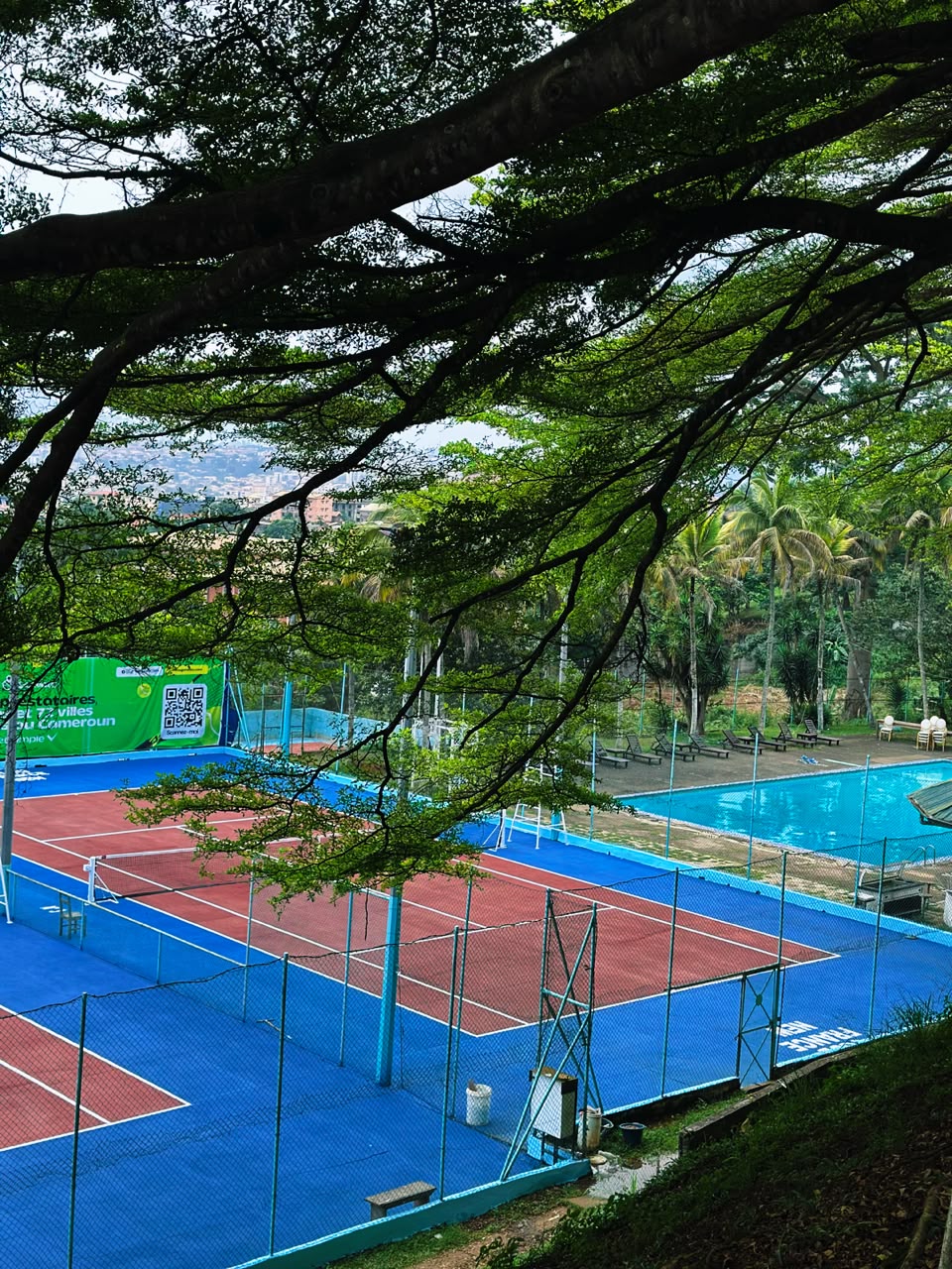 Les courts de tennis et la piscine dans le cadre arboré du Club France New